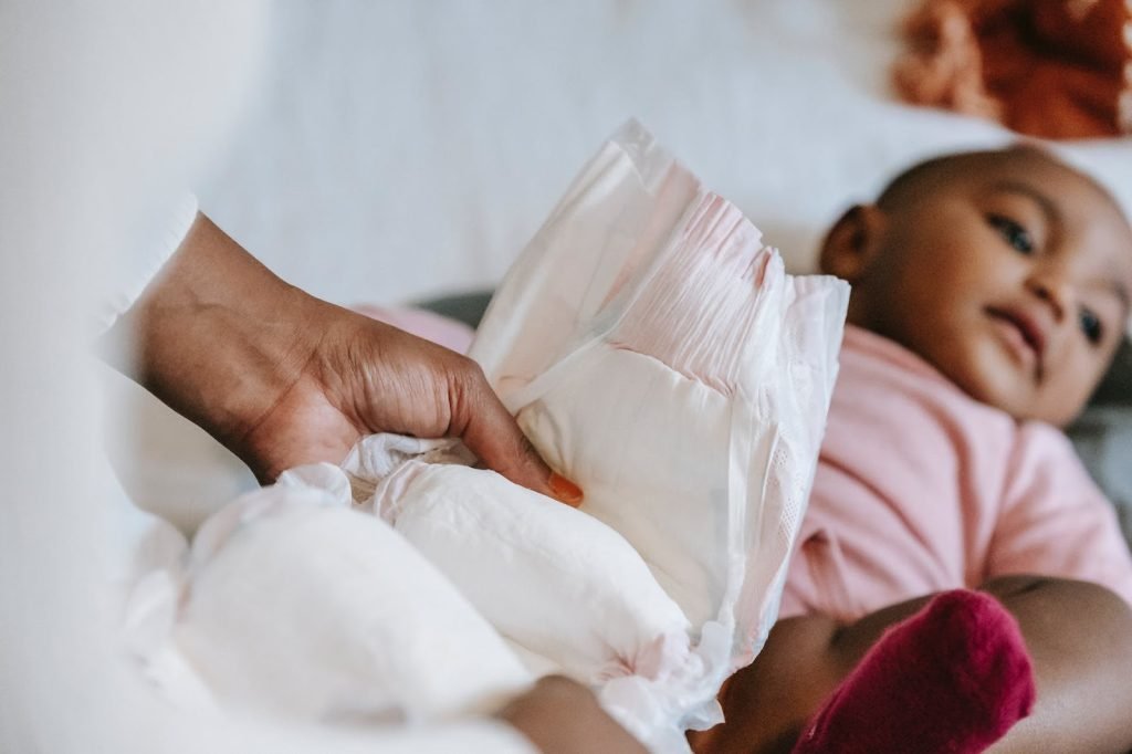 Black mother changing diaper for baby